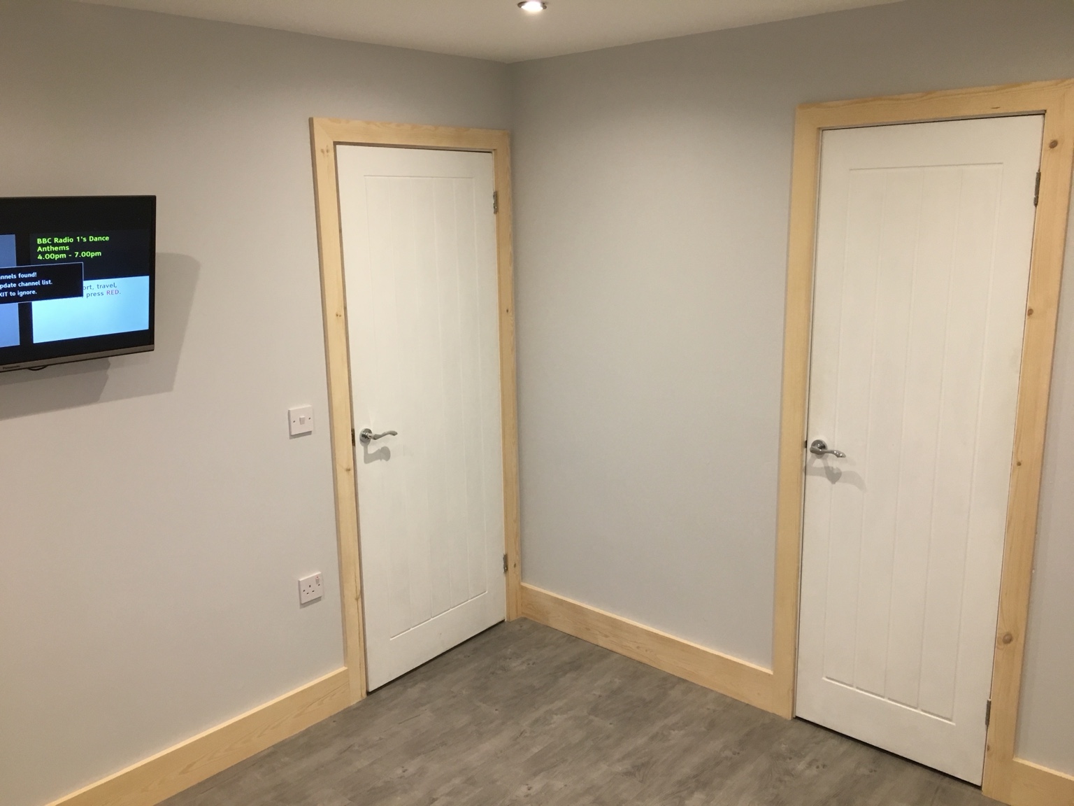 Two fitted white internal doors with timber architraves and skirting, before decorating